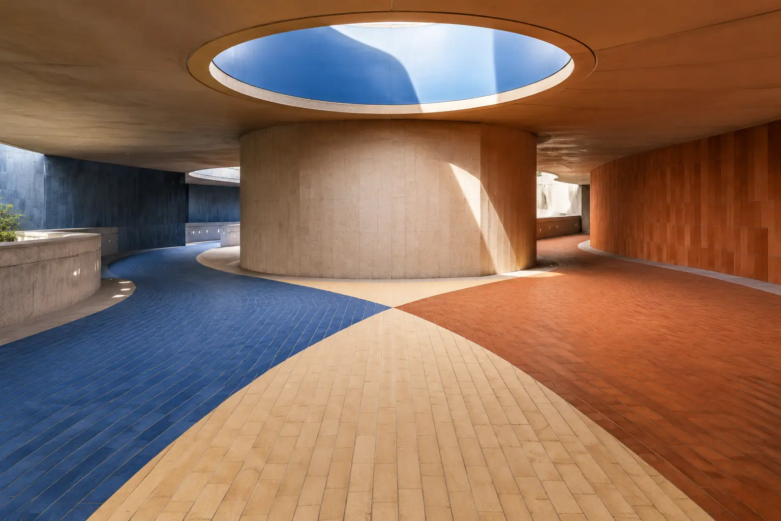 Cobalt and terracotta tiled paths converging beneath a circular skylight